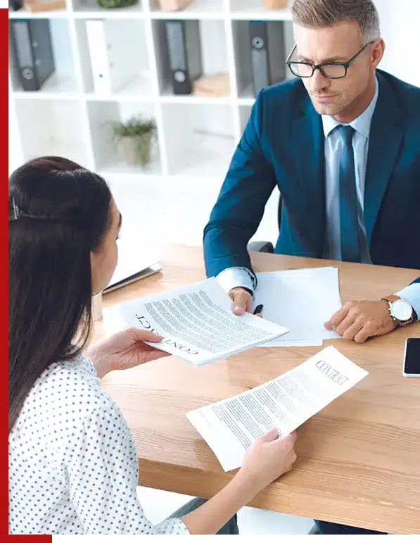 photo of a woman signing papers with lawyer